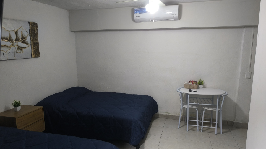 El Loft donde se ve las camas, la mesa y el aire acondicionado