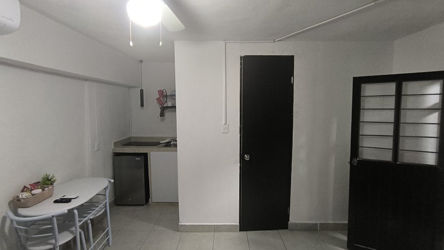 El Loft donde se ve la mesa, la cocineta, la puerta del baño y la  puerta de entrada al Loft