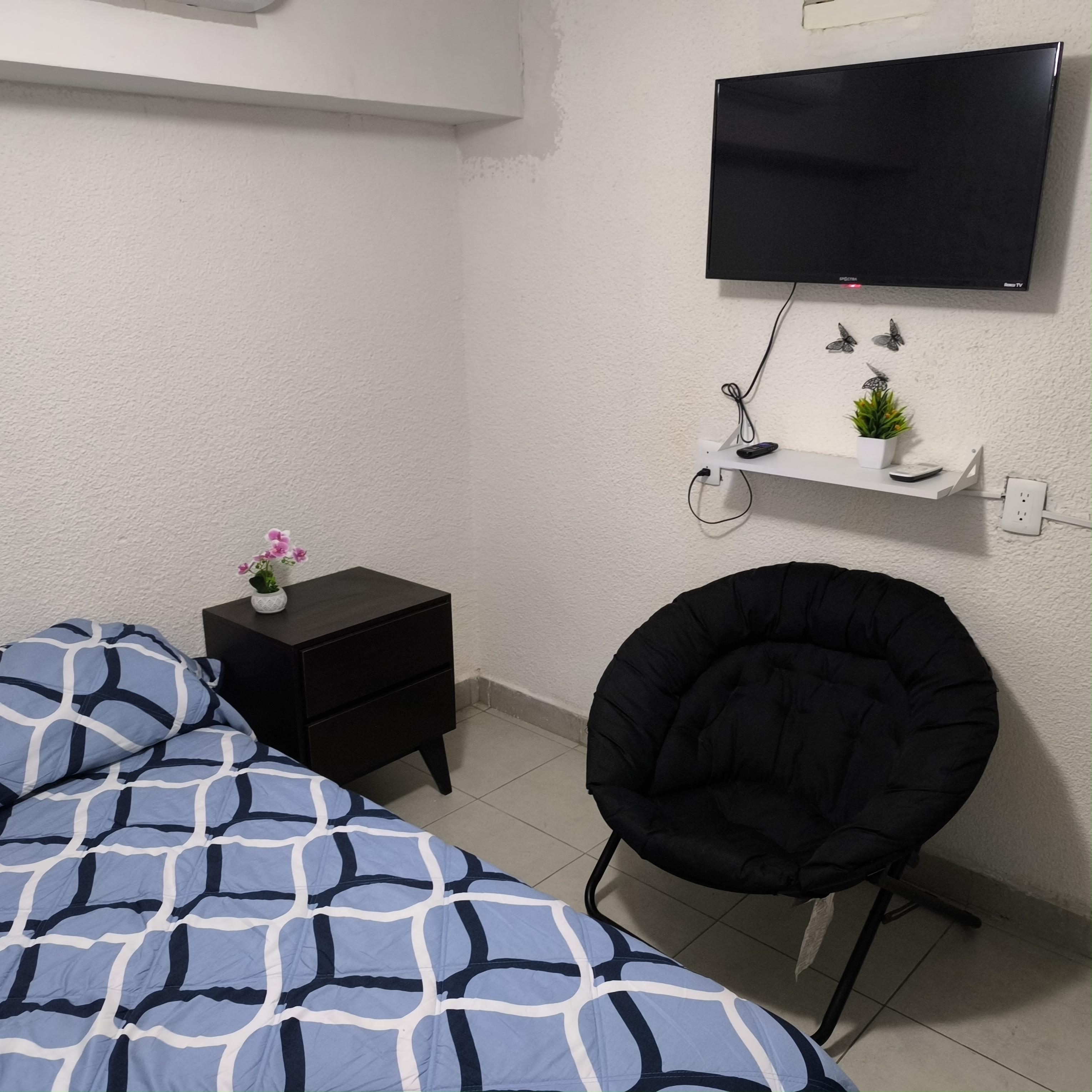 El cuarto 1 del Loft donde se ve la cama, el buró, la silla y la tele