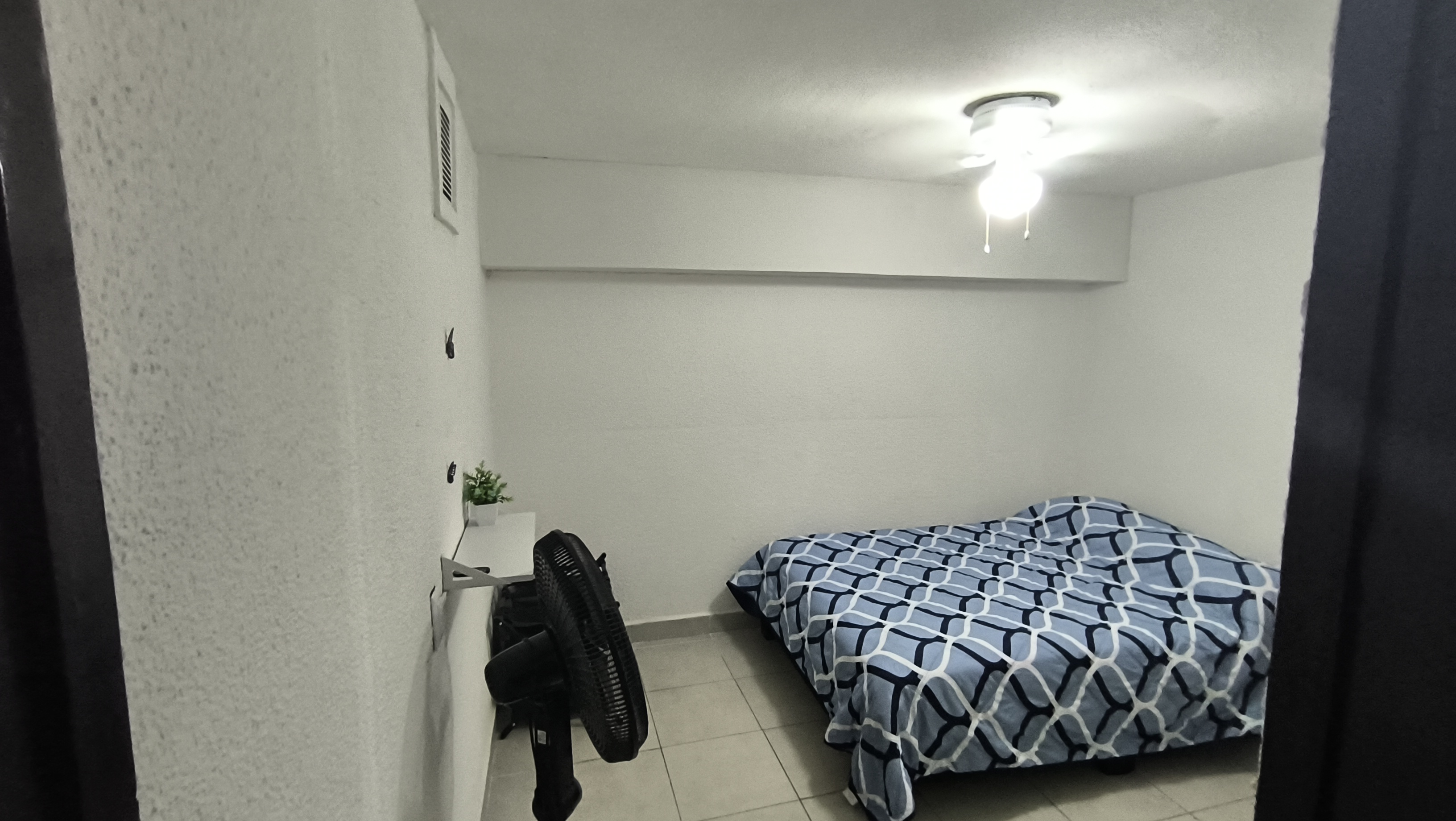 El cuarto 2 del Loft donde se ve la cama y el ventilador